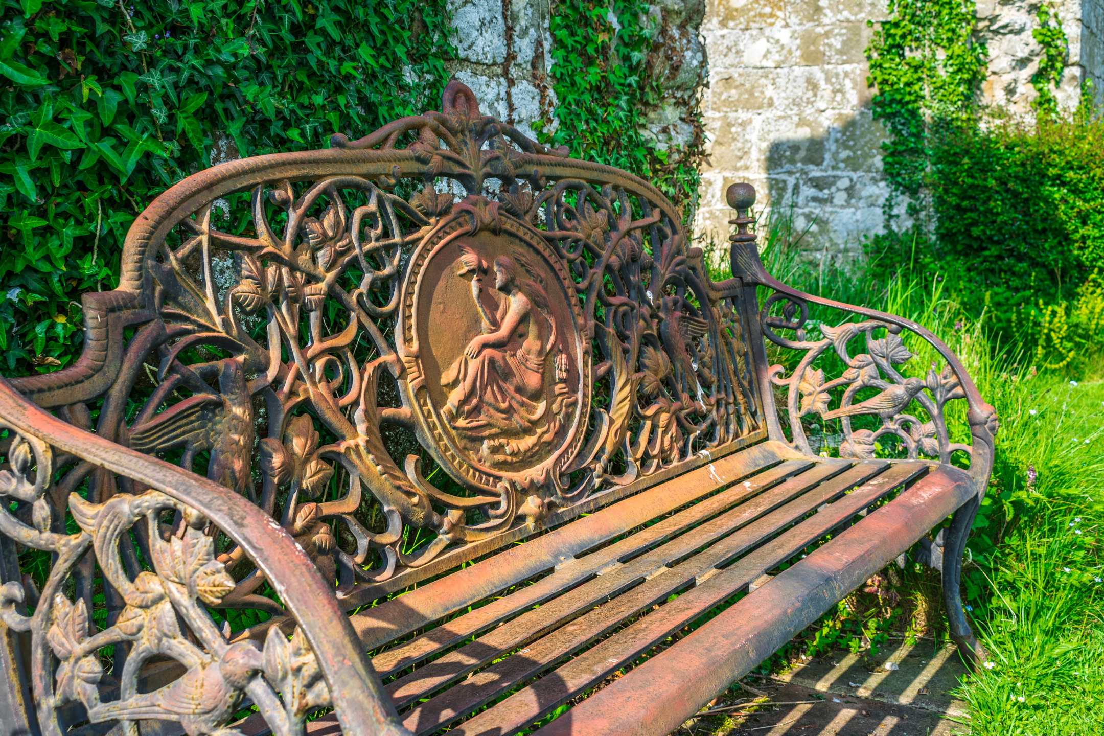 A very ornate wrought iron bench photographed in the grounds of Jervaulx Abbey in North Yorkshire.